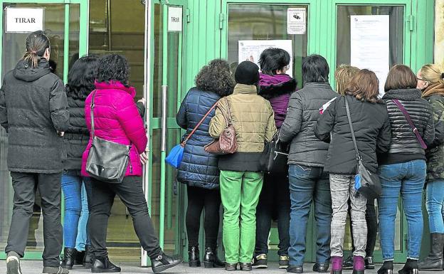 Varios aspirantes a una plaza de personal de servicio consultan los listados en el Aulario de la Universidad de Valladolid, el pasado domingo.