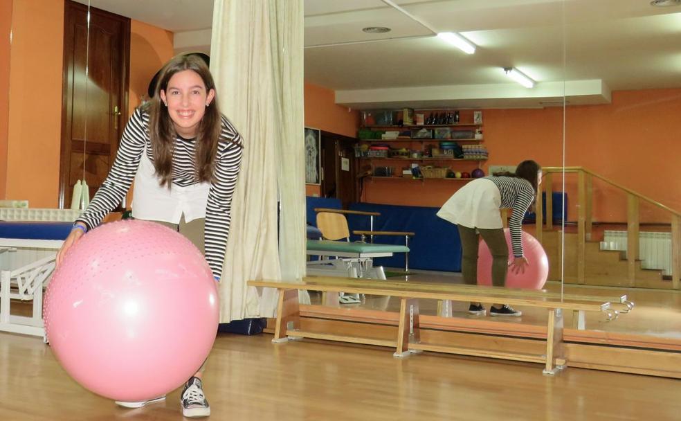 Andrea sujeta un balón de ejercicios en el gimnasio de la Asociación de Esclerosis Múltiple de León.