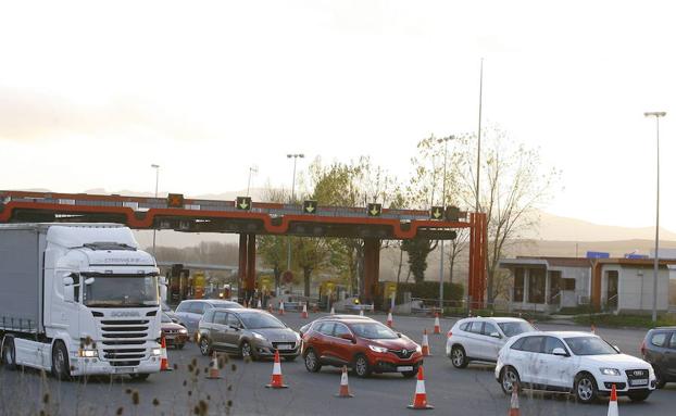 Vehículos pasando un peaje en una autopista.