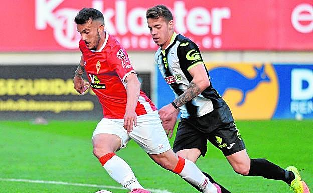 El jugador persigue a un atacante en un partido.