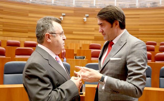 El consejero de Fomento y Medio Ambiente, Juan Carlos Suárez-Quiñones, conversa con el procurador socialista José Ignacio Martín, durante el Pleno de las Cortes de Castilla y León.