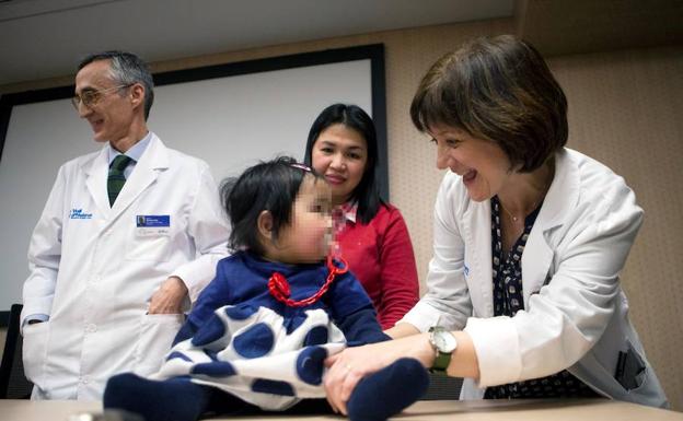 Los doctores Francina Munell (dcha.) y Alfons Macaya (izda.), del hospital Vall d'Hebrón, junto a la niña Beatriz y su madre Marivi.