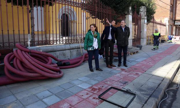 Imagen principal - El Ayuntamiento retira el cableado de la fachada de la iglesia de San Francisco de La Vega, una demanda histórica de los vecinos