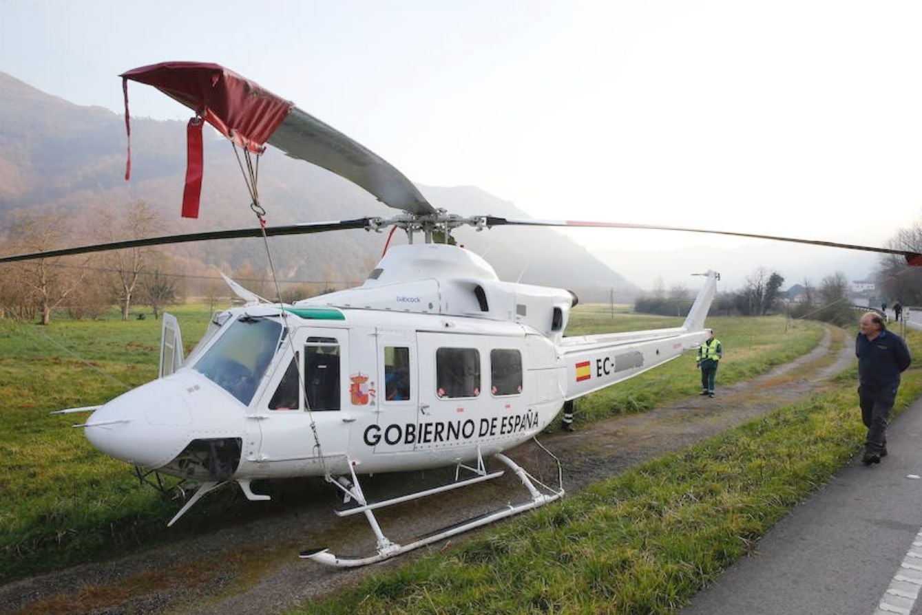 Recuperan el helicóptero de la BRIF de Tabuyo que cayó al río Narcea en Belmonte cuando trabaja en la extinción de un incendio forestal | Ha sido izado por otra aeronave, que lo ha depositado en tierra, donde se trabaja en el desmontaje de las hélices para su evacuación