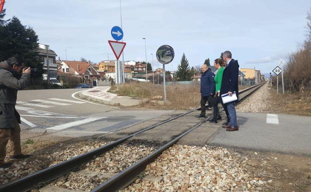 El subdelegado del Gobierno, la delegada del Gobierno y el alcalde de Villaquilambre cruzan las vías en el paso a nivel de El Ejido. 