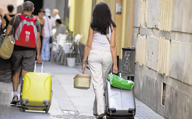 Dos turistas caminan por una calle en Barcelona. 