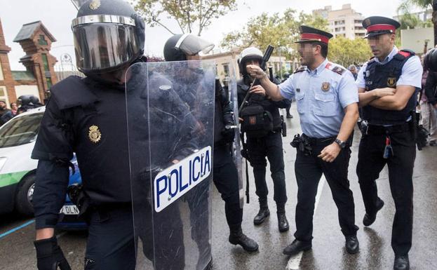 Agentes antidisturbios de la Policía Nacional y de los Mossos discuten durante la jornada del 1-O.