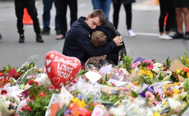 Dos jóvenes neozelandeses se abrazan cerca de una de las mezquitas atacadas este viernes.