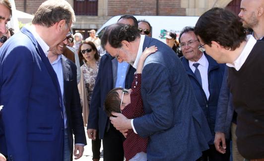 Mariano Rajoy abraza a un niño durante su paseo en las calles de León.