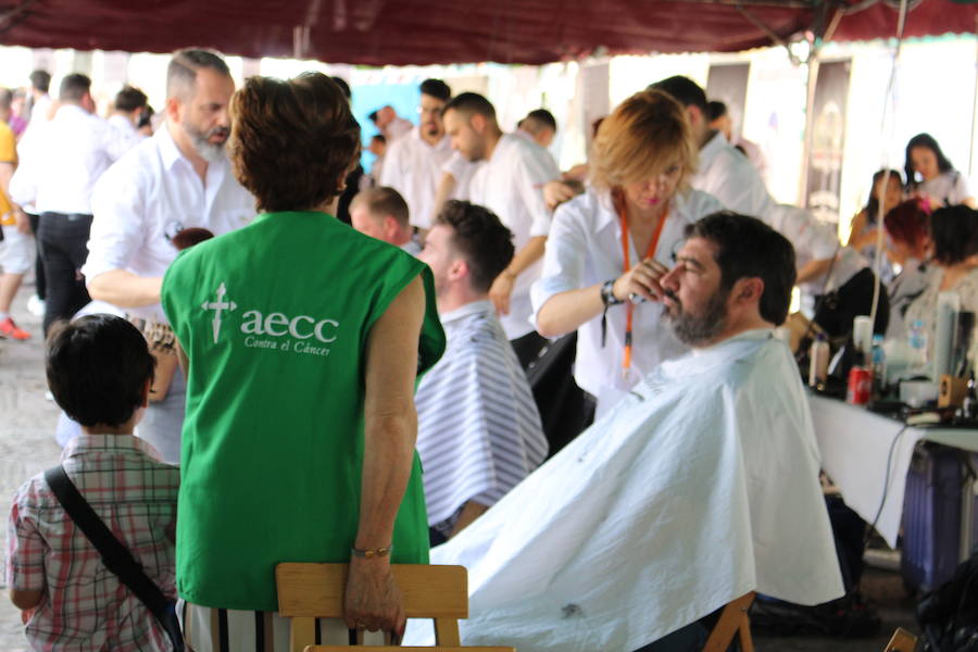 La céntrica plaza de San Marcelo se ha convertido en la jornada del domingo en un improvisado salón de belleza, en el que peluqueros, barberos, tatuadores, maquilladores y masajistas se han puesto a trabajar bajo la iniciativa 'León te corta' promovida por Víctor Valín en favor de la AECC