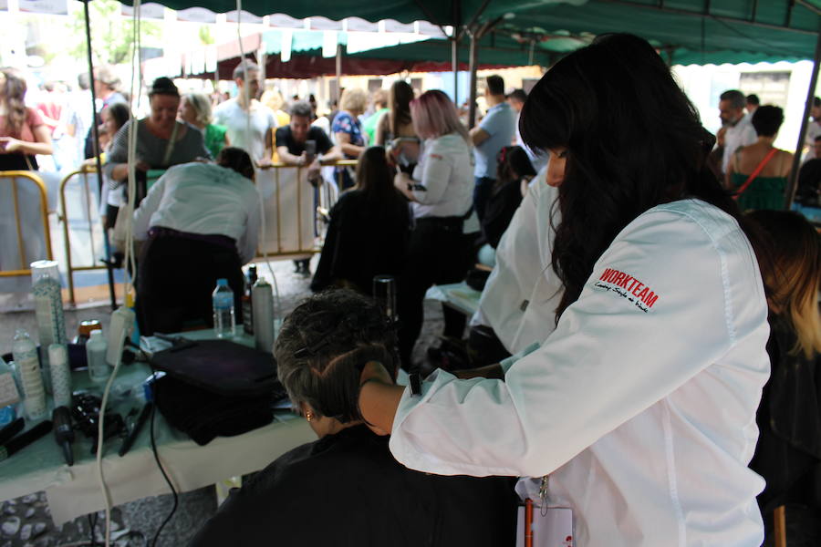 La céntrica plaza de San Marcelo se ha convertido en la jornada del domingo en un improvisado salón de belleza, en el que peluqueros, barberos, tatuadores, maquilladores y masajistas se han puesto a trabajar bajo la iniciativa 'León te corta' promovida por Víctor Valín en favor de la AECC