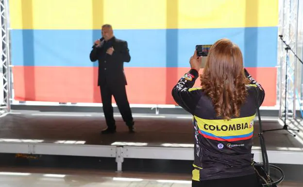 Imagen. Una joven realiza una fotografía en la feria. 