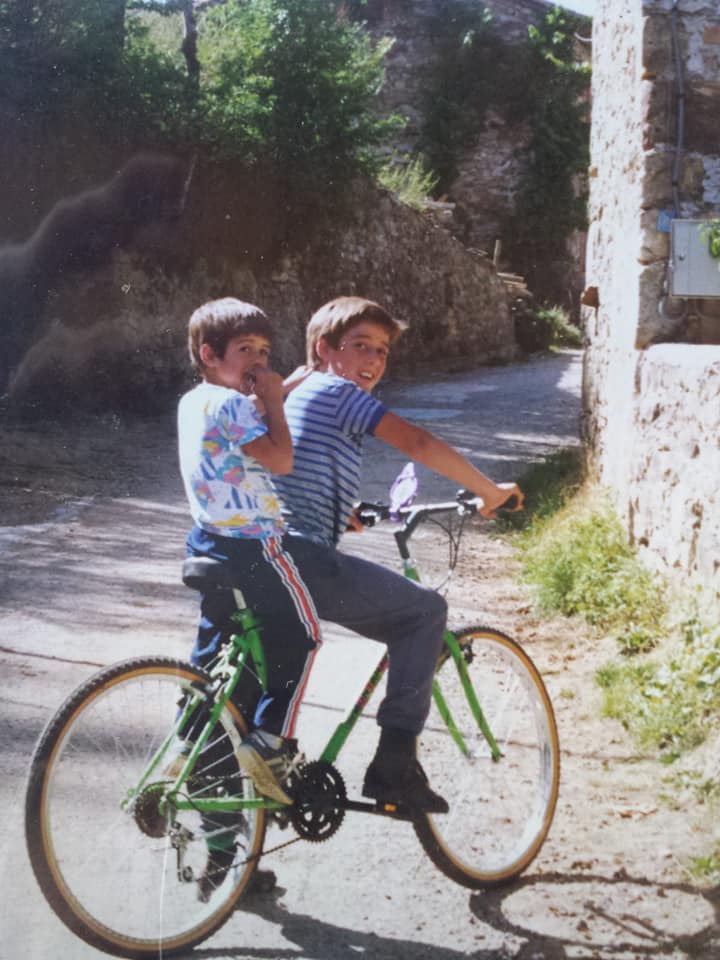 Dos niños en el pueblo disfrutan de un paseo en bici compartida. 