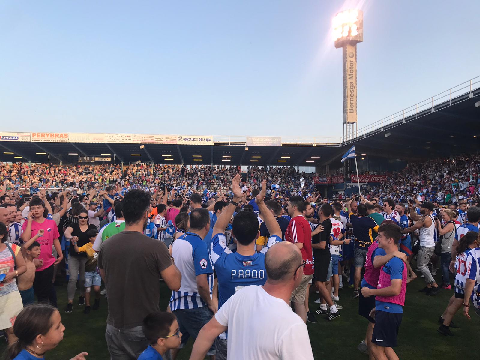 Los aficionados celebran el ascenso sobre el terreno de juego de El Toralín.