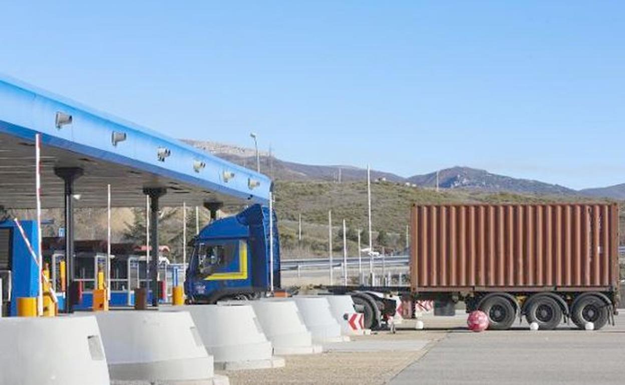 Un transporte de contenedores ante las cabinas de peaje de la autopista del Huerna.