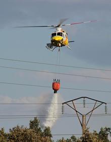 Imagen secundaria 2 - Brigadistas y helicópteros trabajando en la zona del incendio.
