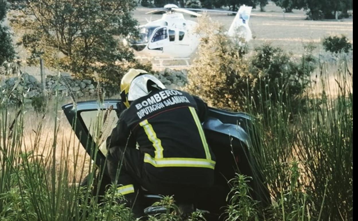 Los bomberos intentan rescatar a una persona, con la imagen del helicóptero de Sacyl al fondo. 