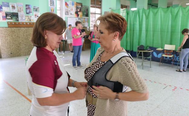 Imagen. Raquel Fernández coloca los protectores a Maribel. 