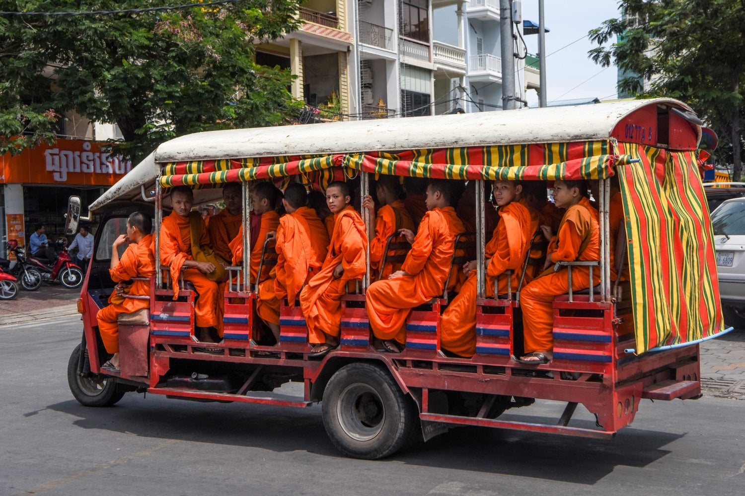 Monjes budistas montan en un tuk-tuk en Phnom Penh, Camboya