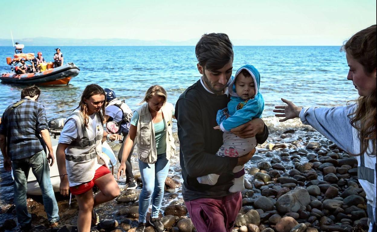 Migrantes rescatados desembarcan en la isla griega de Lesbos, tras cruzar el mar Egeo desde Turquía.