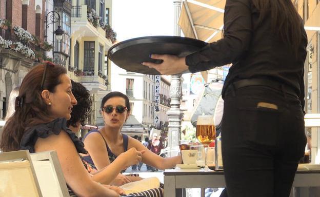 Una camarera atiende en una terraza de la calle Ancha de León capital.