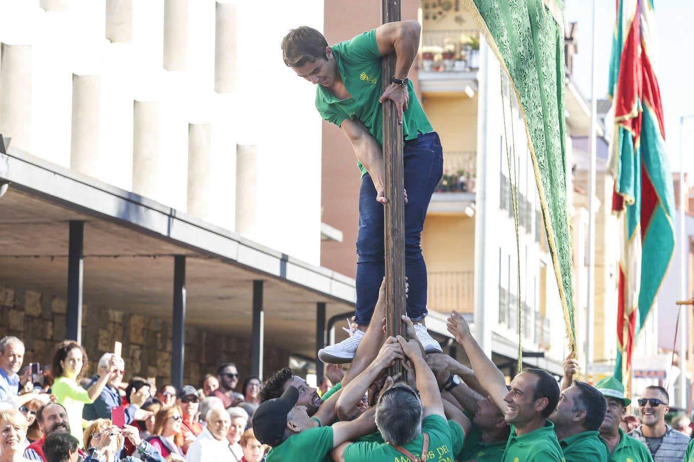 Un mozo subiendo al mástil de un pendón. 