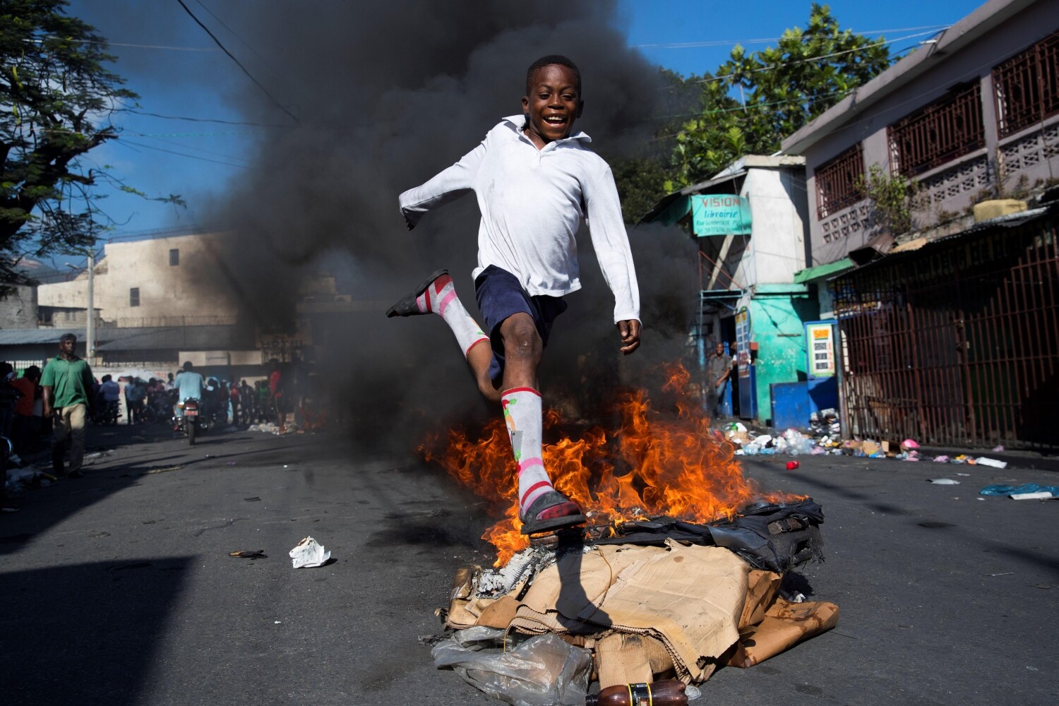 Un niño salta una barricada en llamas cerca del mercado de Petionville, durante una jornada de protestas, en Puerto Príncipe (Haití). 