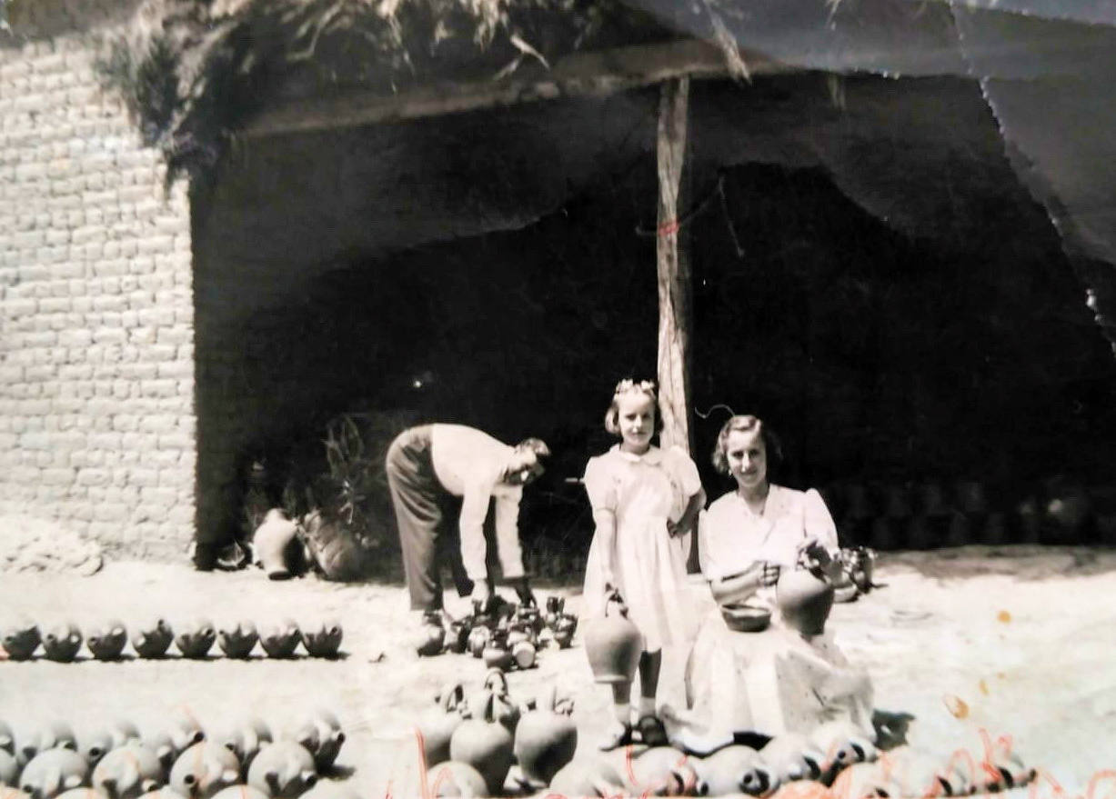 Antonio Lobato, alfarero, años después, faenando en el corral de su casa. En primer término sus hijas. 