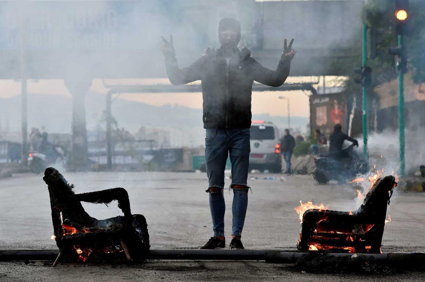 Un manifestante hace el gesto de la victoria en una protesta en Beirut, Líbano