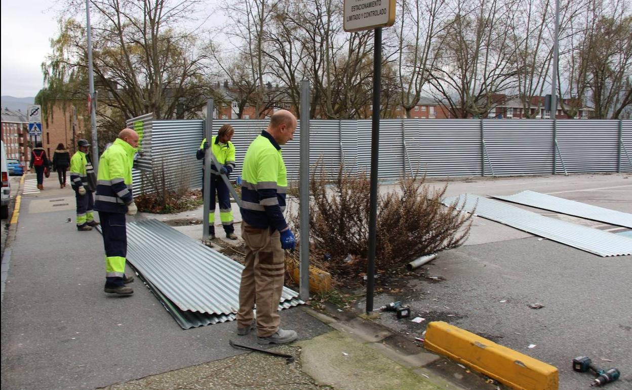 Operarios municipales retiran el vallado para reabrir el aparcamiento de Obispo Osmundo.