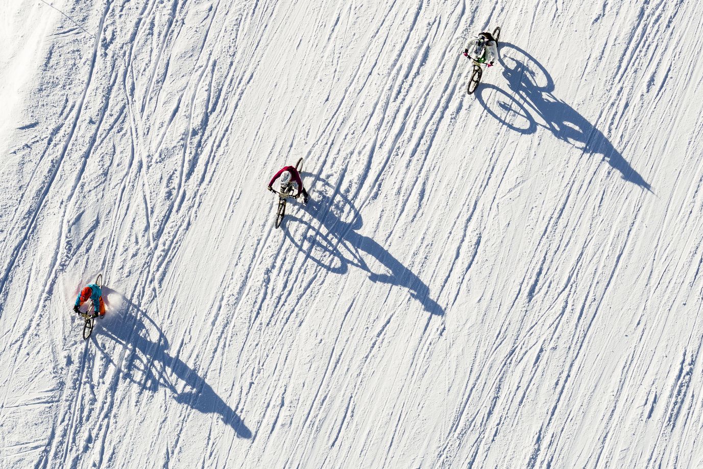 Fotografía realizada por un dron que muestra a varios ciclistas participando en la San Silvestre por la nieve en la estación de esquí de Villars-Sur-Ollon, Suiza.