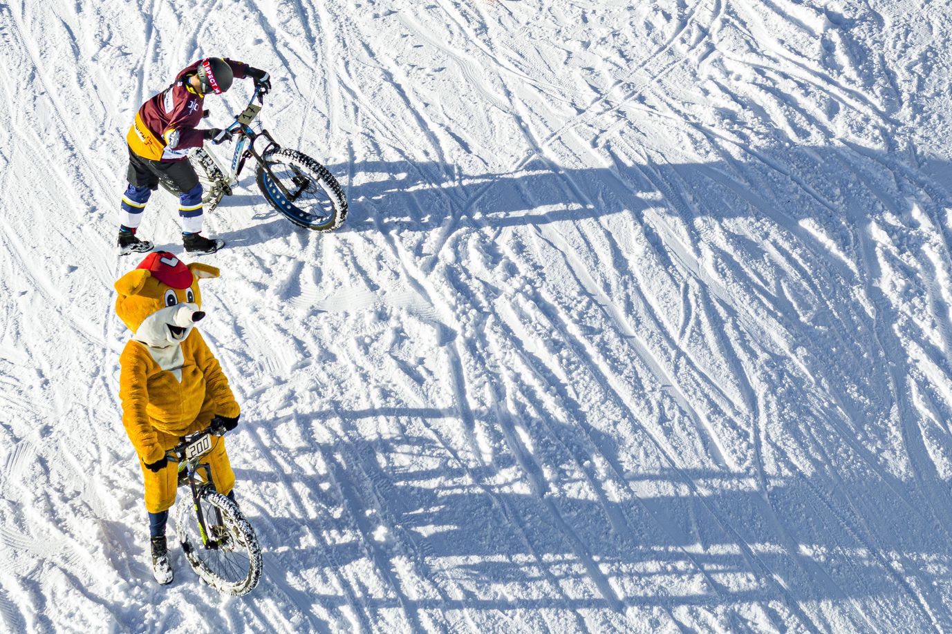 Fotografía realizada por un dron que muestra a varios ciclistas participando en la San Silvestre por la nieve en la estación de esquí de Villars-Sur-Ollon, Suiza.