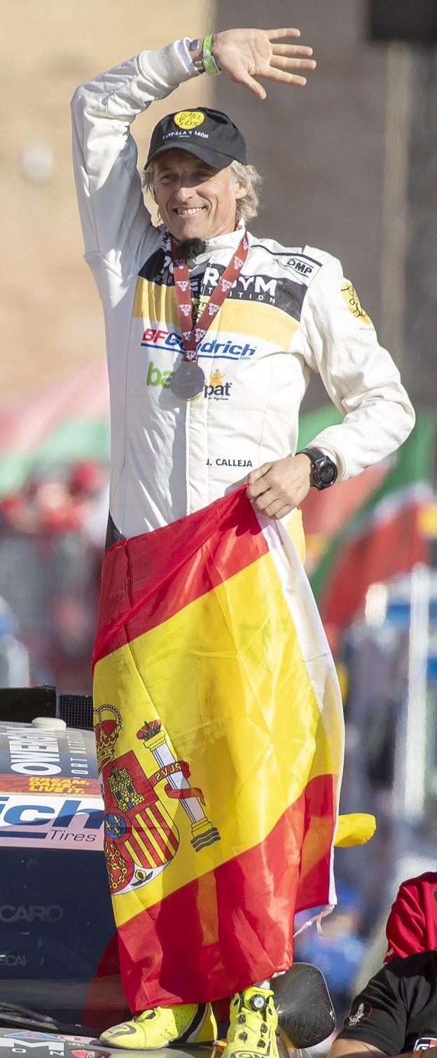 Jesús Calleja, envuelto en la bandera de España, tras finalizar el Dakar.