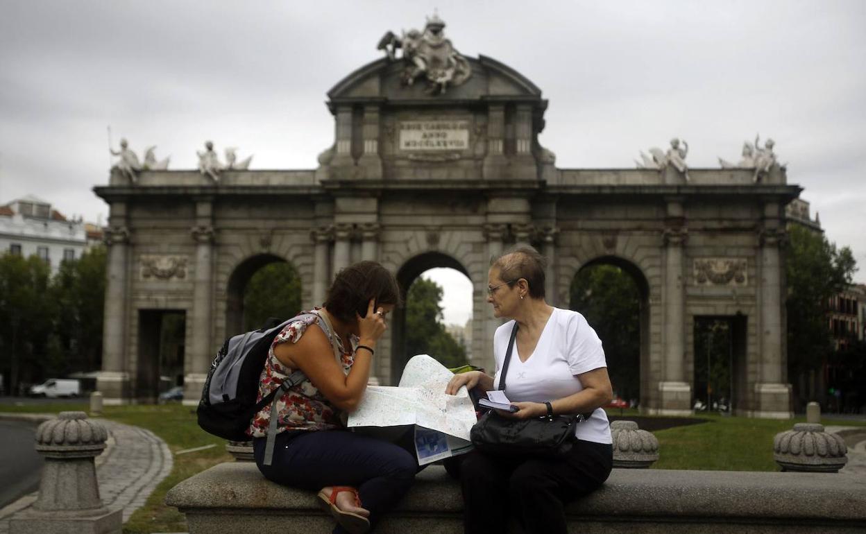 Turistas frente a la Puerta de Alcalá, en Madrid.