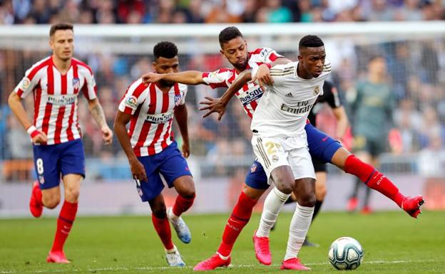 Vinicius, perseguido por tres futbolistas del Atlético. 