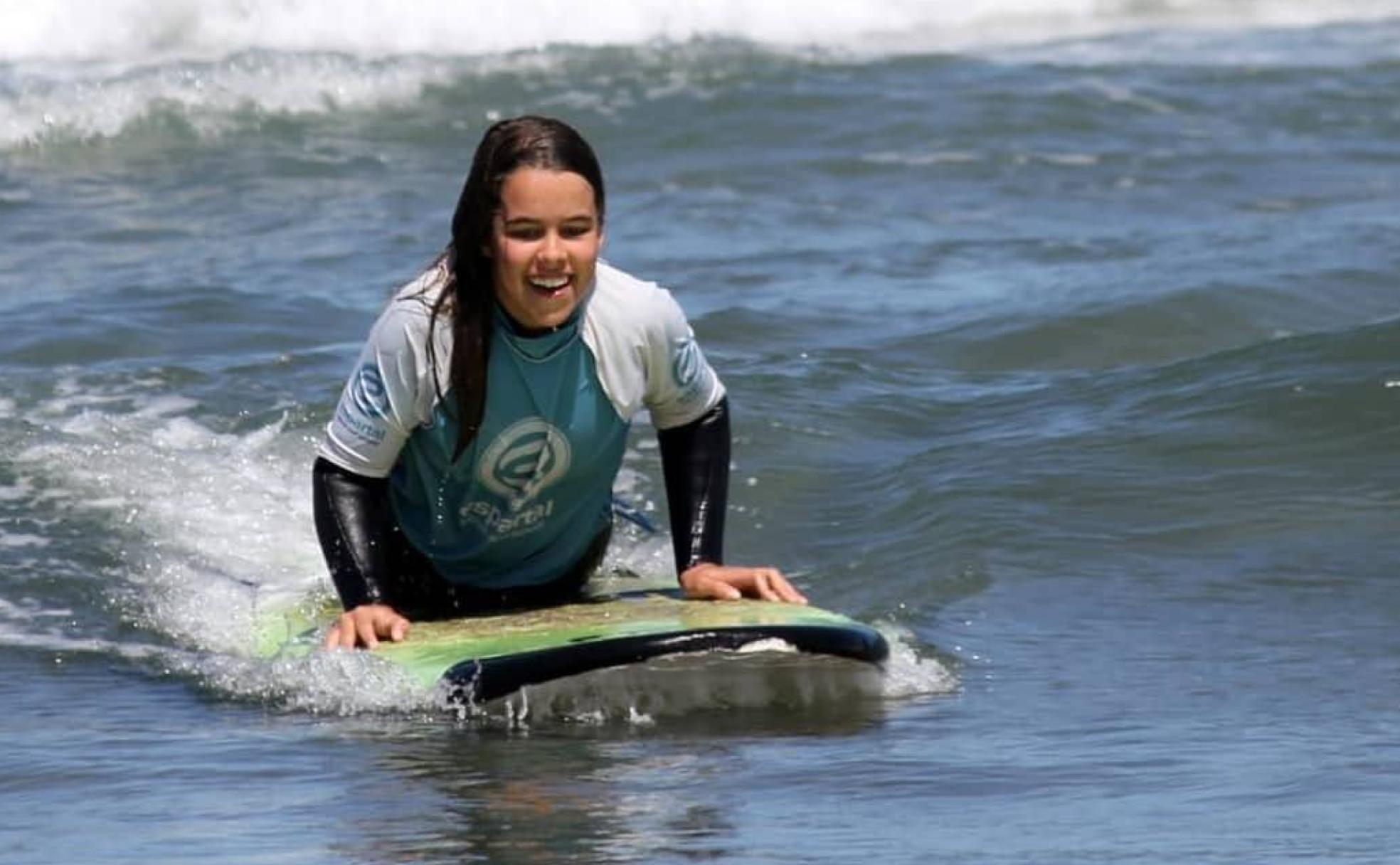 María sobre la tabla de surf en la playa de San Juan de la Arena, Asturias. 