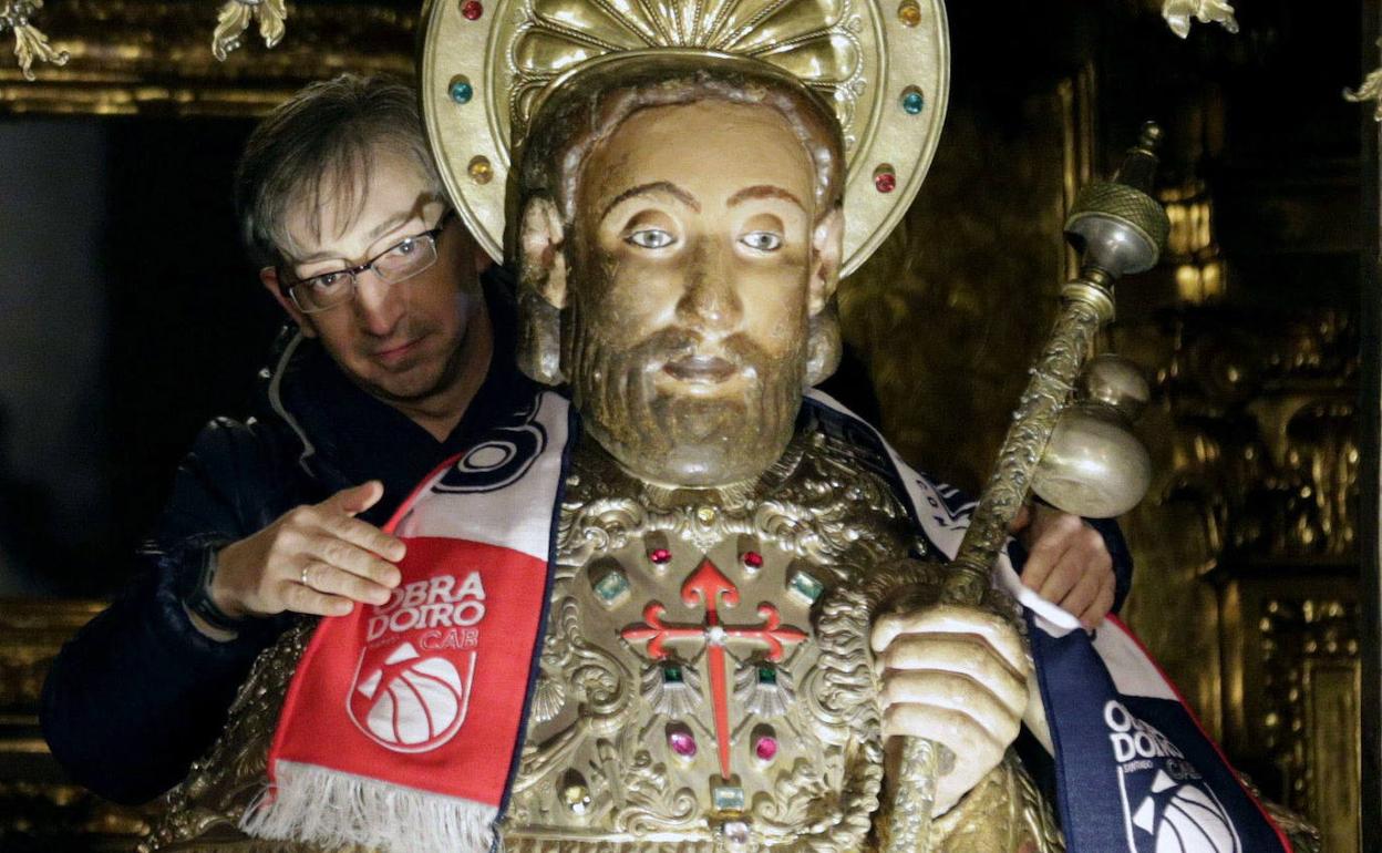 Un hombre da el tradicional abrazo a la estatua del apóstol Santiago en la catedral, en una imagen de archivo.