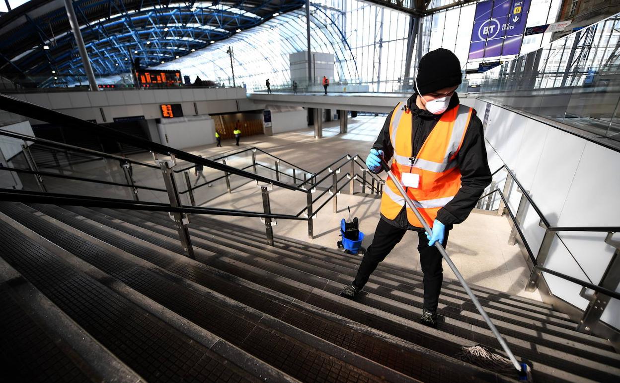 Un empleado limpia la estación londinense de Waterloo, en la que casi no hay público.