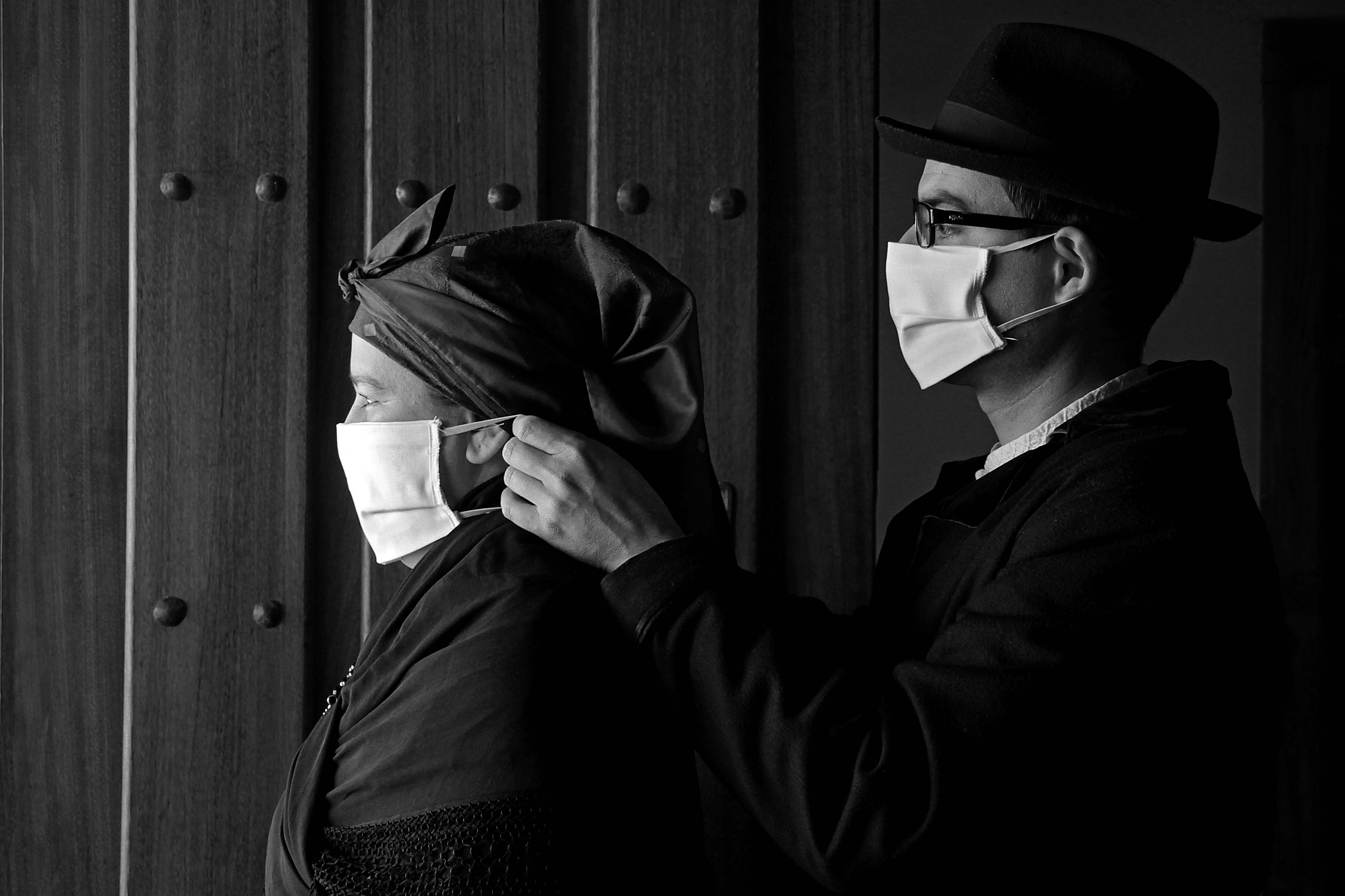 Un matrimonio y su hija, vestidos con indumentaria tradicional leonesa, se protegen contra la infección del coronavirus en Carrizo.