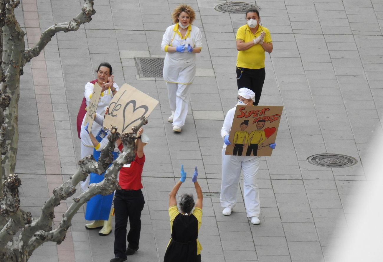 Trabajadores de los supermercados en la barriada de Eras de Renueva salen a la calle para aplaudir a los vecinos. Corazones y gratitud al aire para animar a los residentes en el duro confinamiento.