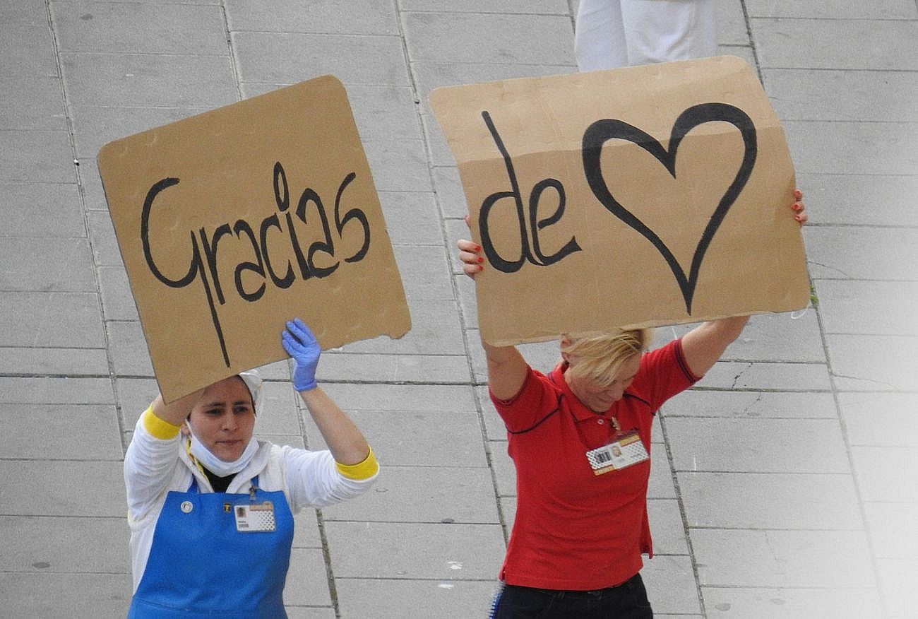 Trabajadores de los supermercados en la barriada de Eras de Renueva salen a la calle para aplaudir a los vecinos. Corazones y gratitud al aire para animar a los residentes en el duro confinamiento.