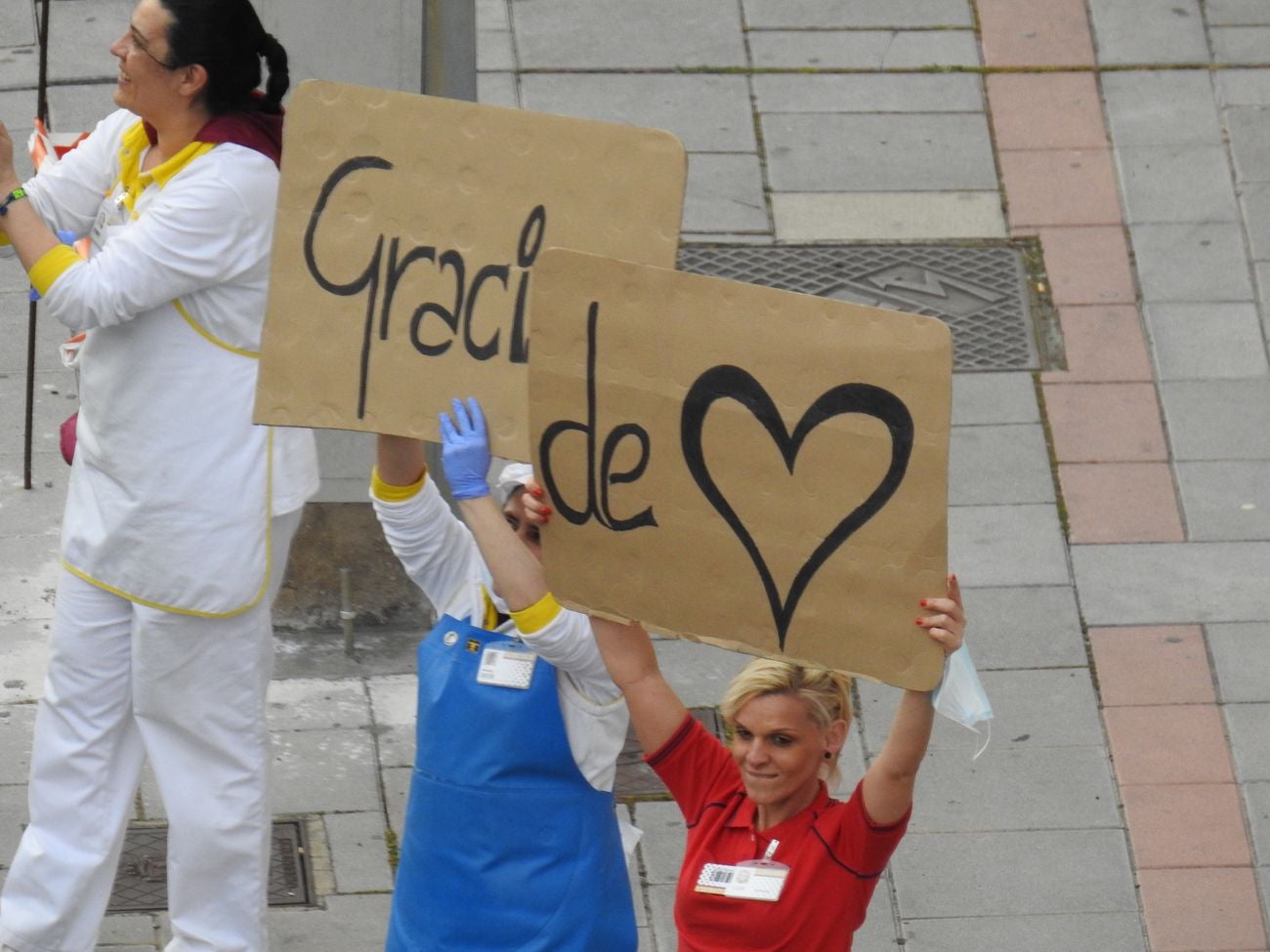 Trabajadores de los supermercados en la barriada de Eras de Renueva salen a la calle para aplaudir a los vecinos. Corazones y gratitud al aire para animar a los residentes en el duro confinamiento.