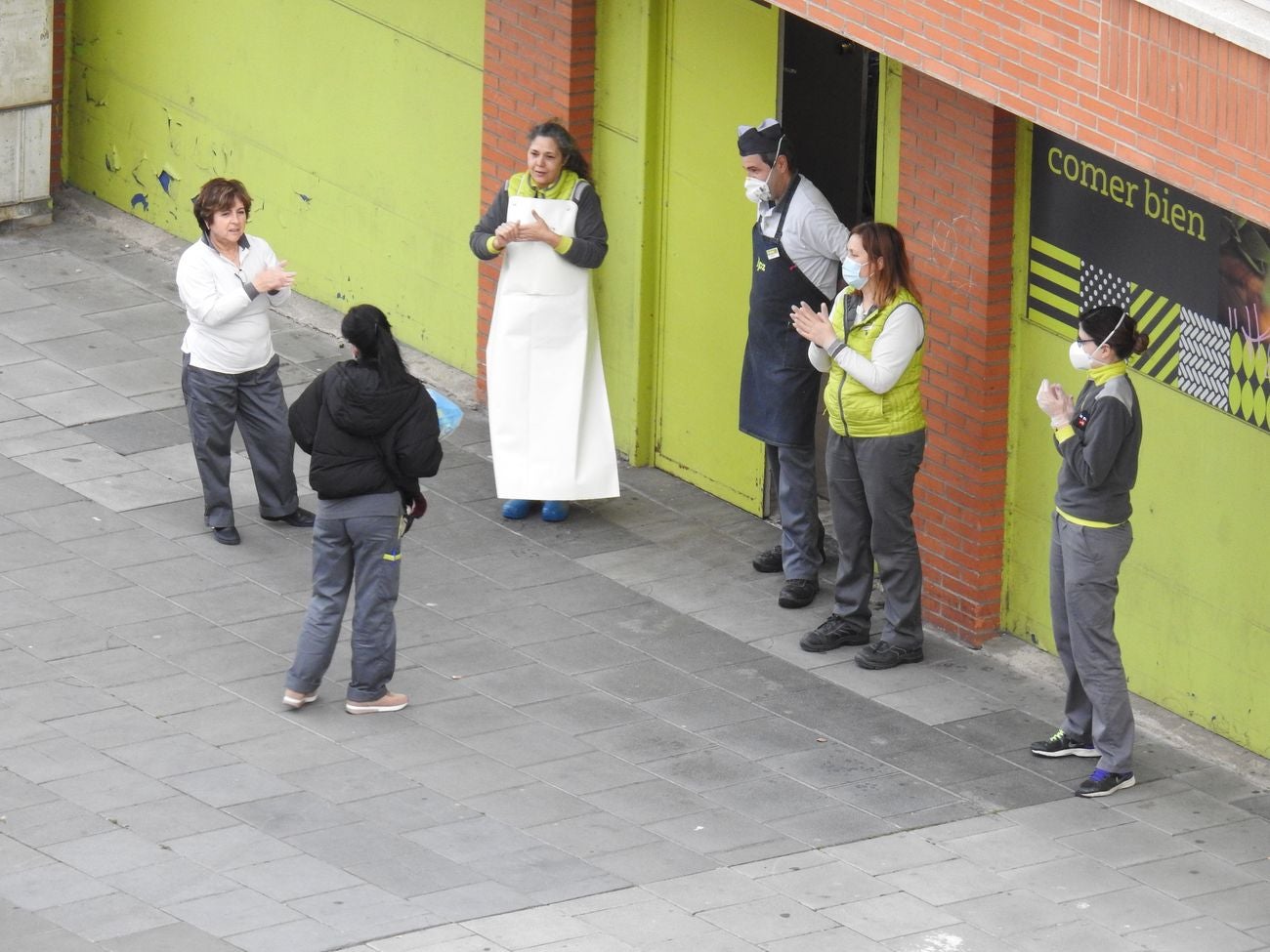 Trabajadores de los supermercados en la barriada de Eras de Renueva salen a la calle para aplaudir a los vecinos. Corazones y gratitud al aire para animar a los residentes en el duro confinamiento.