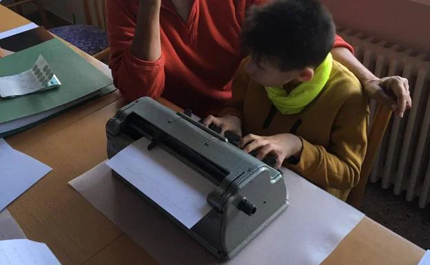 Un niño ciego escribe en braille con la máquina de escribir Perkins.
