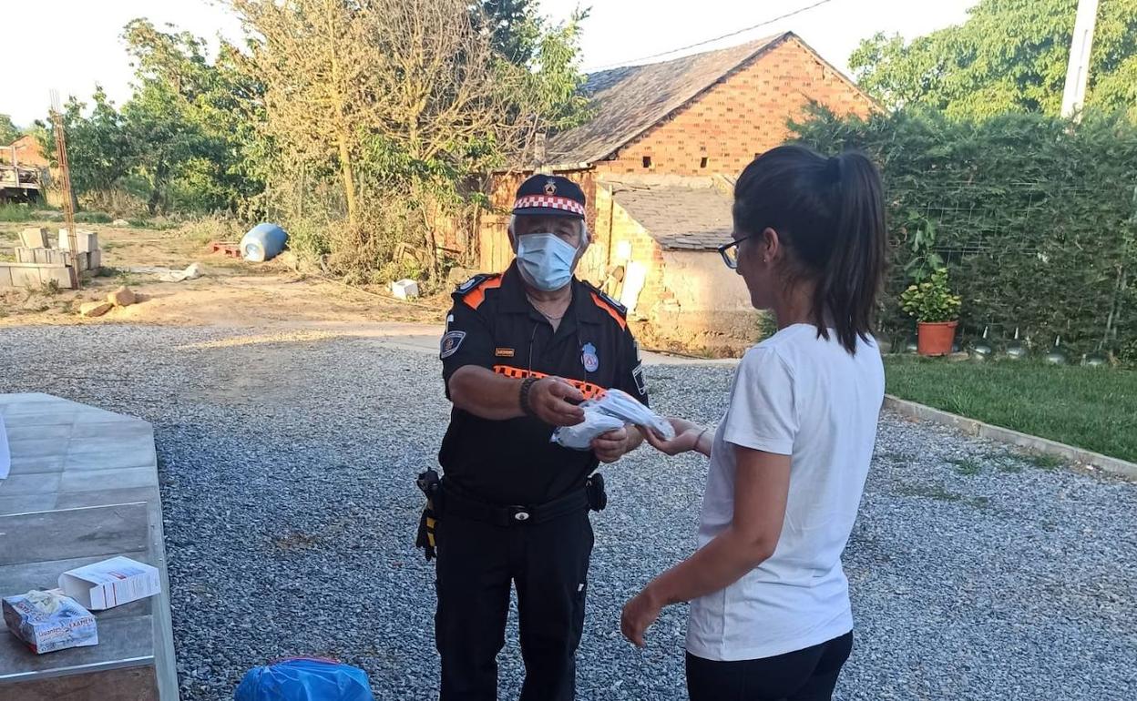 Voluntarios de Protección Civil reparten mascarillas en Carracedelo.
