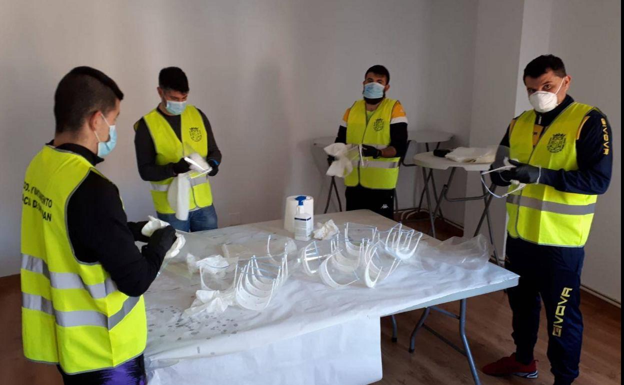Los voluntarios preparan las mascarillas para los vecinos.