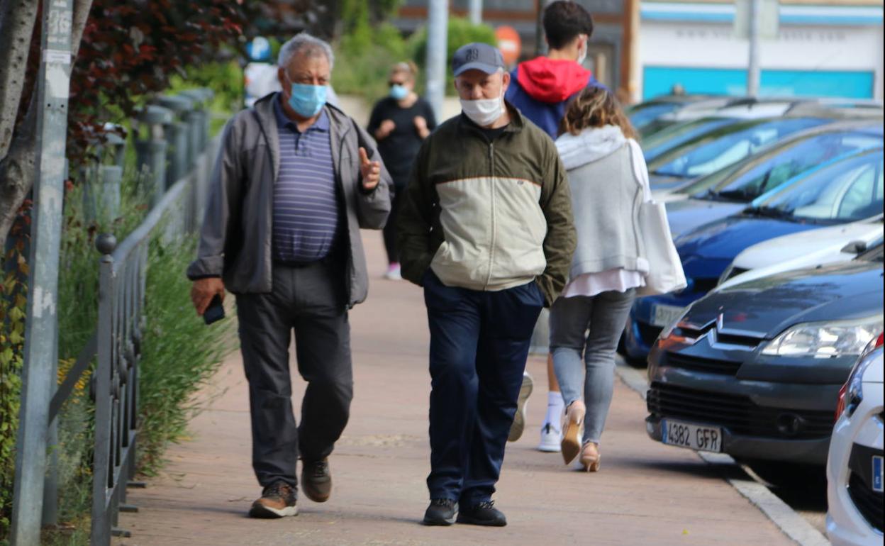 Un grupo de personas camina por las calles de León con sus mascarillas.