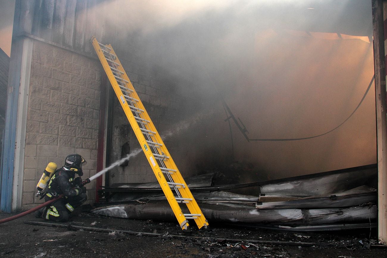 Efectivos del Cuerpo de Bomberos de León intervienen en un incendio originado en una nave en el municipio de Valverde de la Virgen. 