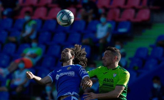 Cucurella y Burgos saltan en busca de un balón. 