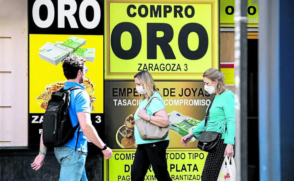 Recurso socorrido. Transeúntes pasan frente a una tienda de compraventa de oro en una céntrica calle de Sevilla.